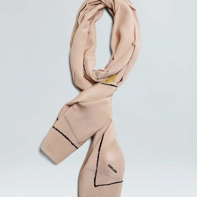 Cachecol bege com linhas pretas e palavra CALVIN bordada