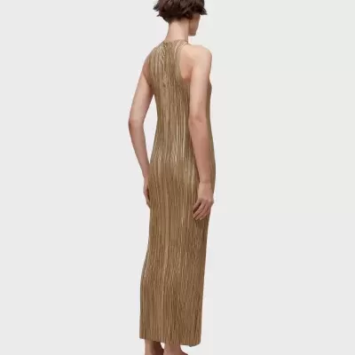 Vestido dourado comprido sem mangas visto de costas, modelo com chinelos castanhos.