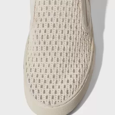 Ténis creme slip-on com padrão texturizado e sola branca