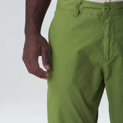 Calções verdes de tecido liso usados por uma pessoa e fundo branco