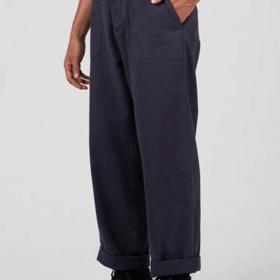 Calças largas azul escuro com dobras e ténis pretos com sola vermelha