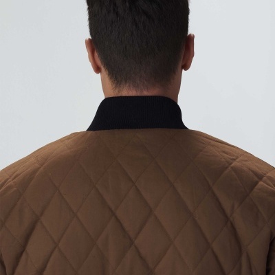 Casaco acolchoado castanho com padrão de losangos e gola preta