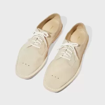 Sapatos masculinos de couro bege com cadarços brancos sobre fundo branco