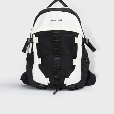 Mochila preta e branca com cordões elásticos frontais e logo OSKLEN