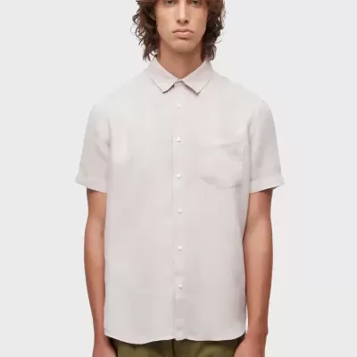 Homem com camisa bege clara de manga curta e calças verde-oliva