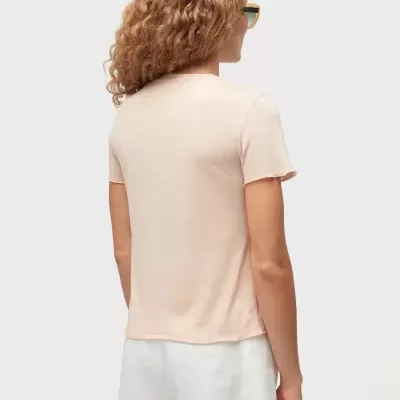 Mulher de costas com t-shirt bege e calções brancos