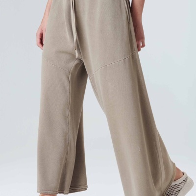 Calças largas bege com ténis brancos em fundo branco