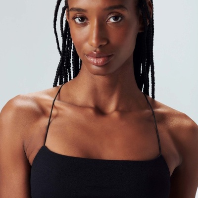 Top de bikini preto com alças finas em fundo branco