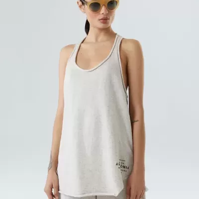 Top feminino cinza claro com texto ÁLOMIA e calças largas da mesma cor, usando óculos de sol amarelos.