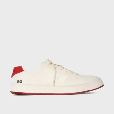 Sapatilha branca com detalhes vermelhos e letras 'ag' na lateral.