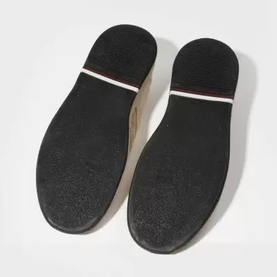 Solas pretas texturadas de sapatos com risca vermelha e branca, vista inferior