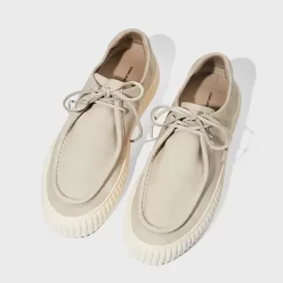 Sapatos de sola grossa bege com atacadores em fundo branco
