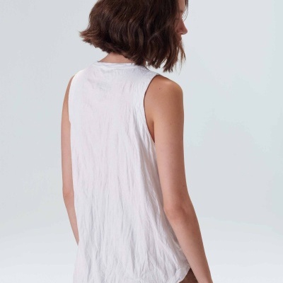 Top branco sem mangas visto pelas costas numa mulher com cabelo castanho curto