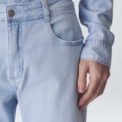 Calças e camisa de ganga azul clara, detalhe de bolso e botão metálico