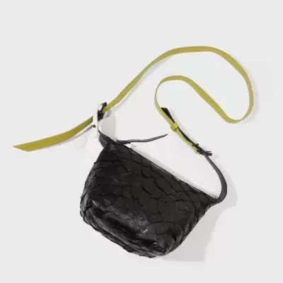 Mala preta com textura de escamas e alça amarela ajustável