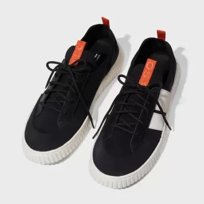 Par de sapatilhas pretas com sola branca e etiqueta laranja.