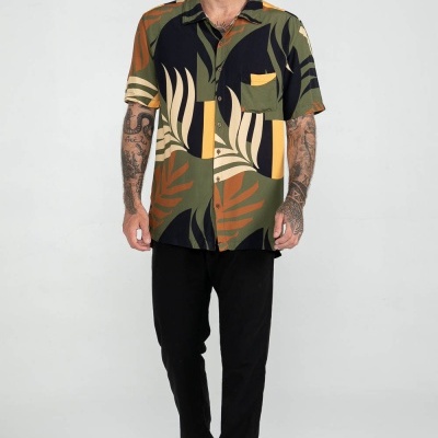 Homem com camisa colorida e calças pretas em fundo branco