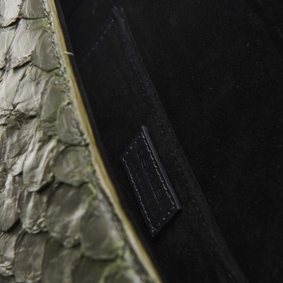 Mala em pele com textura de escamas verde-oliva e interior preto.