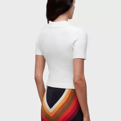 Blusa branca de malha canelada gola polo com calças listradas em várias cores