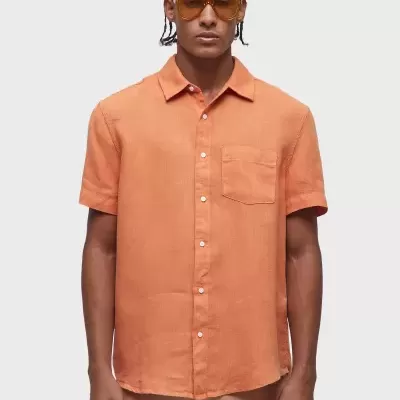 Camisa masculina laranja com bolso e botões, modelo com óculos de sol