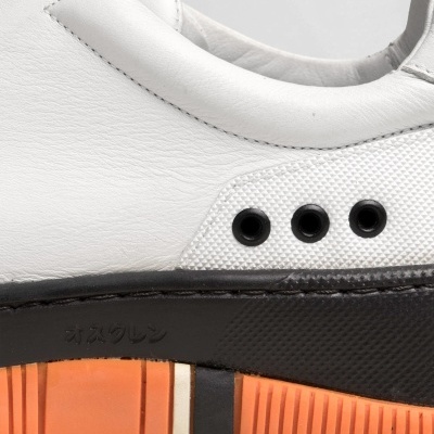 Sapata branca em couro com sola preta e laranja