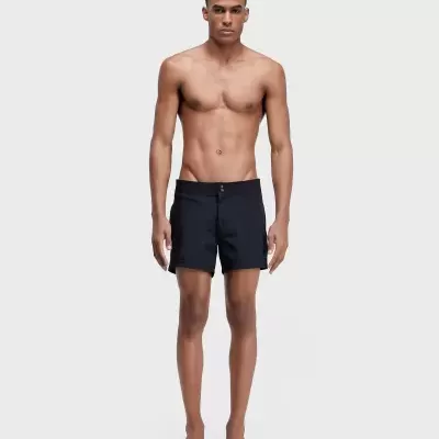 Homem com calções pretos simples posando em fundo branco