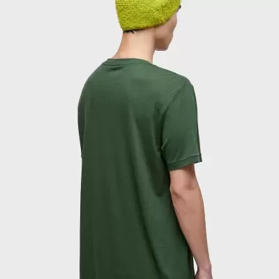 Pessoa de costas com t-shirt verde escura e gorro amarelo vivo