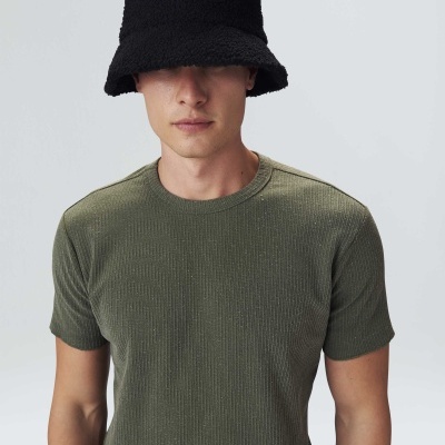 Homem com t-shirt verde e chapéu preto tipo balde