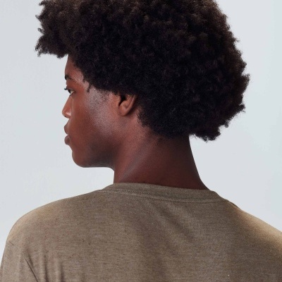 Pessoa de costas com t-shirt bege e cabelo afro preto