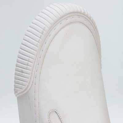 Sapatilha branca com sola grossa texturizada e detalhe elástico lateral.