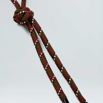 Corda trançada castanho, vermelho, branco e preto com extremidades pretas e nó simples.