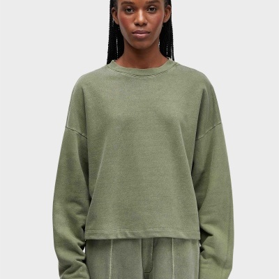Sweatshirt verde-oliva de manga comprida com gola redonda numa modelo.