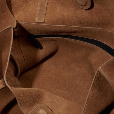 Interior de saco de pele castanha com fecho e botão magnético