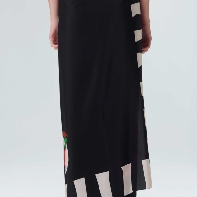 Saia comprida preta com padrão listrado branco nas bordas e detalhe colorido na parte inferior.