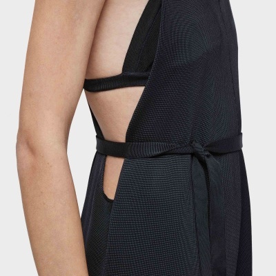 Vista lateral de um vestido preto com cinto e corte aberto nas laterais