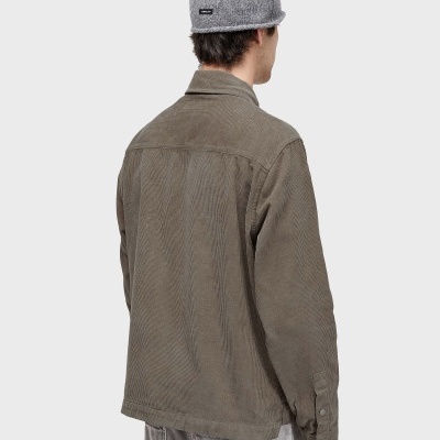 Vista traseira de homem com camisola castanha de veludo, calças cinza e gorro cinza de malha com etiqueta OSKLEN