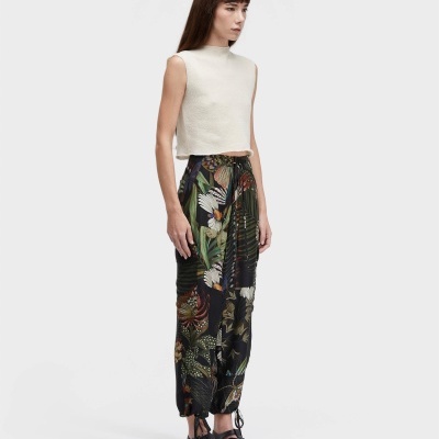 Mulher com top branco creme e calças com padrão floral