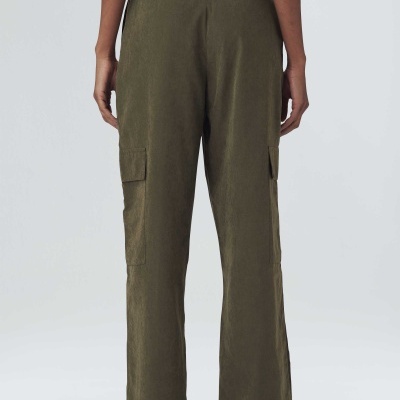 Calças verdes de tecido com bolsos laterais usadas por pessoa vista de costas