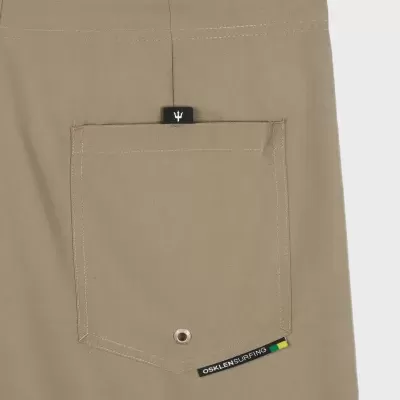 Bolso traseiro bege com etiquetas OSKLEN SURFING e bandeira do Brasil