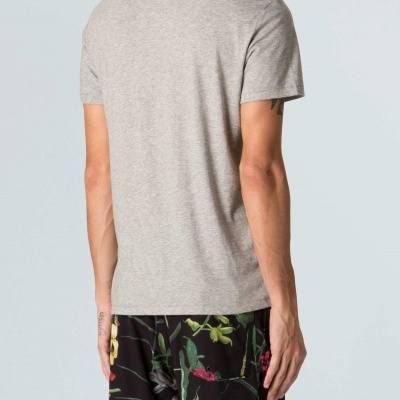 Homem de costas com t-shirt cinzenta e calções pretos florais