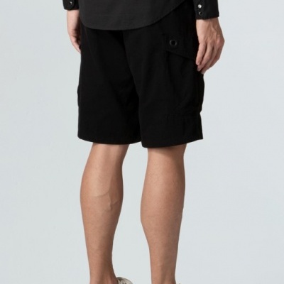 Calções pretos masculinos com bolso lateral, camisa preta e sapatos bicolores