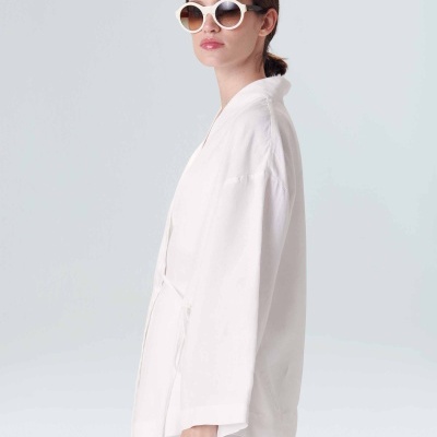 Mulher com kimono branca e óculos de sol redondos brancos