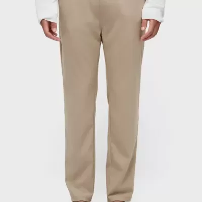 Calças bege com cintura elástica e sandálias de tiras castanhas