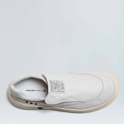 Sapato branco slip-on com sola bege e etiquetas na língua