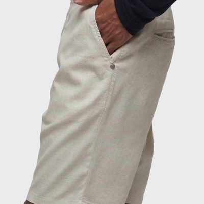 Calções de tecido bege claro com bolsos laterais e bolso traseiro, usados por pessoa com camisola preta