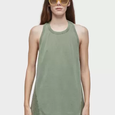 Mulher com top verde-oliva e óculos de sol amarelos