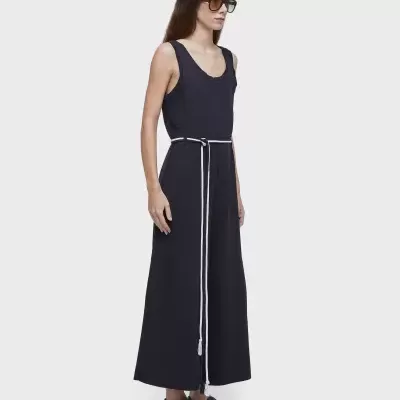 Vestido preto comprido de alças com cinto branco e óculos de sol.