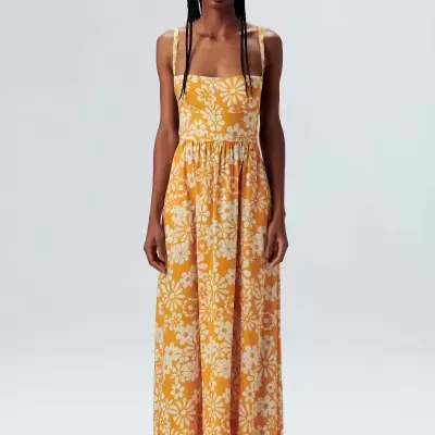 Vestido amarelo comprido com flores brancas em fundo branco