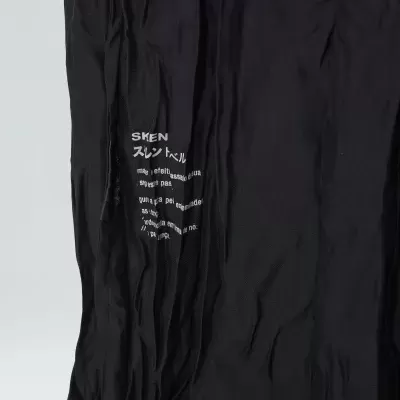 Peça de vestuário preta com texto branco e caracteres japoneses