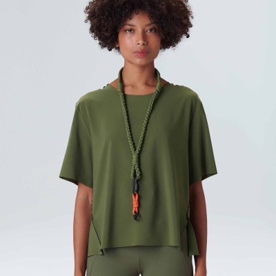 Mulher com conjunto desportivo verde-oliva e cordão trançado